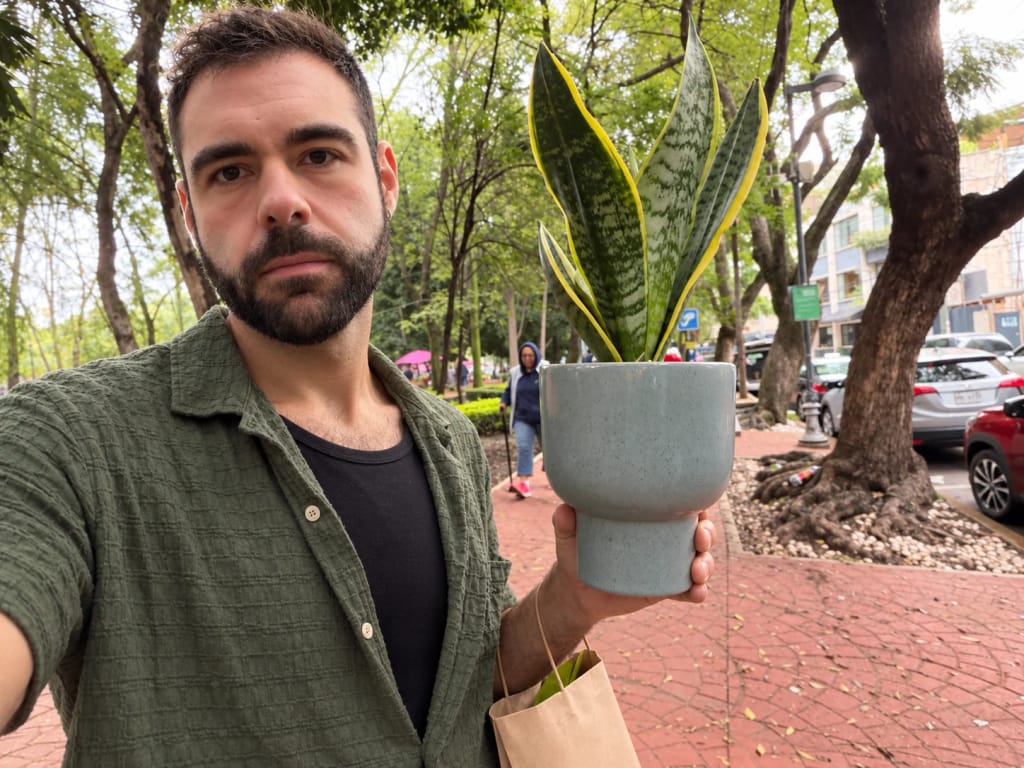 Mark Spirek outdoors holding a potted snake plant